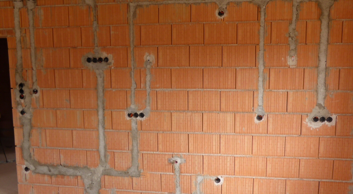 Téglafalba süllyesztett védőcsövek és kötődobozok.